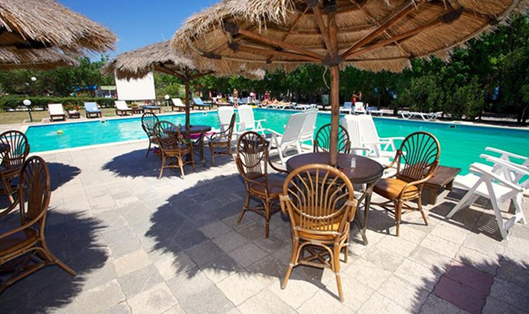 Фото отеля («Голубой залив» пансионат) - Столы возле бассейна